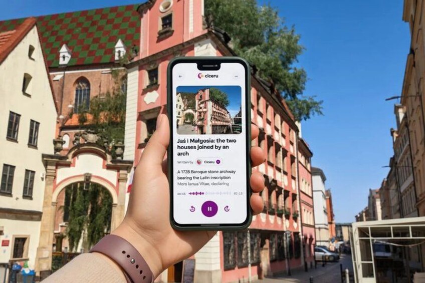 A hand holding a smartphone displaying a historical article about Matgosis houses. 1