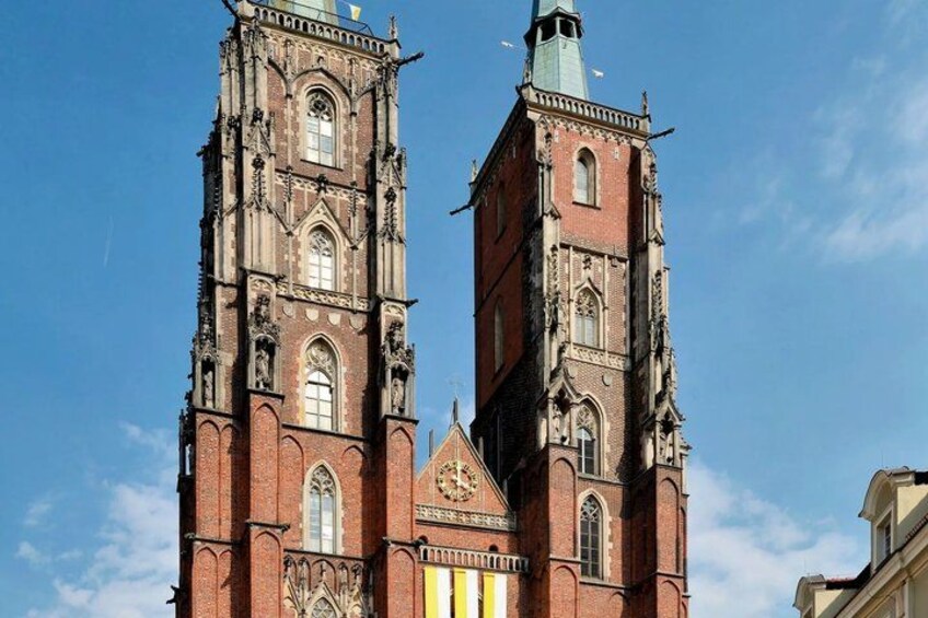 A historic church with two tall towers, intricate Gothic architecture, and a clear blue sky. 2