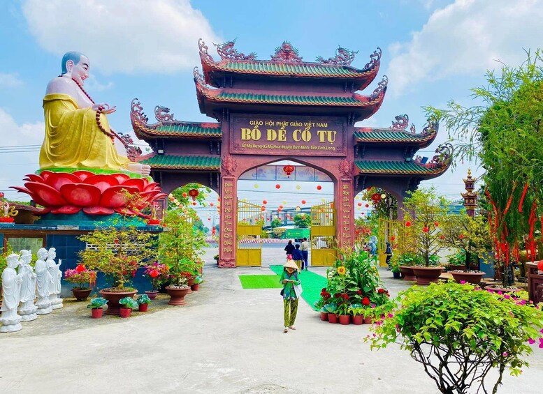 Ein traditionelles vietnamesisches Tor mit einer großen Buddha-Statue und Lotusblumen. 5