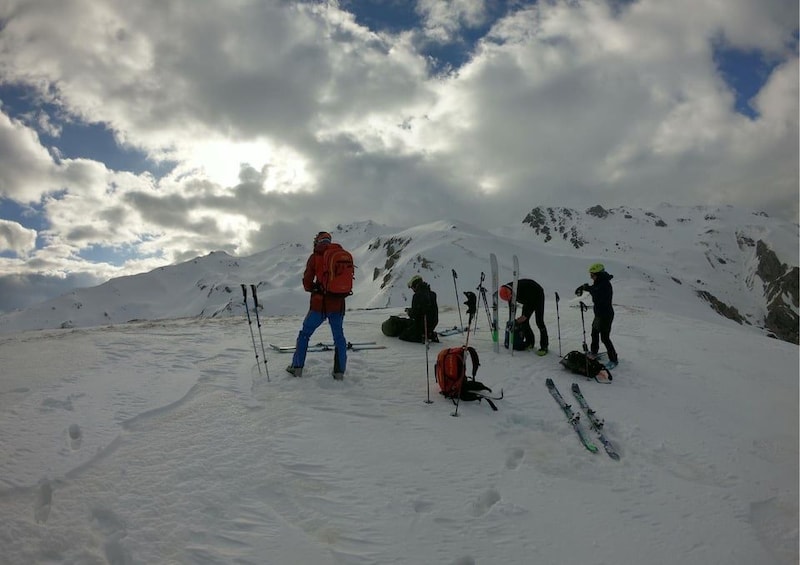 A group of skiers on a snowy mountain with a cloudy sky. 5