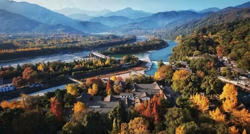 A river winding through a valley with autumn foliage, surrounded by mountains. 2