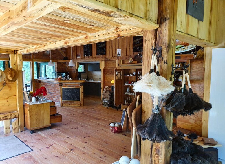 A rustic wooden interior with a bar area, wooden beams, and a hanging feathered decoration. 3