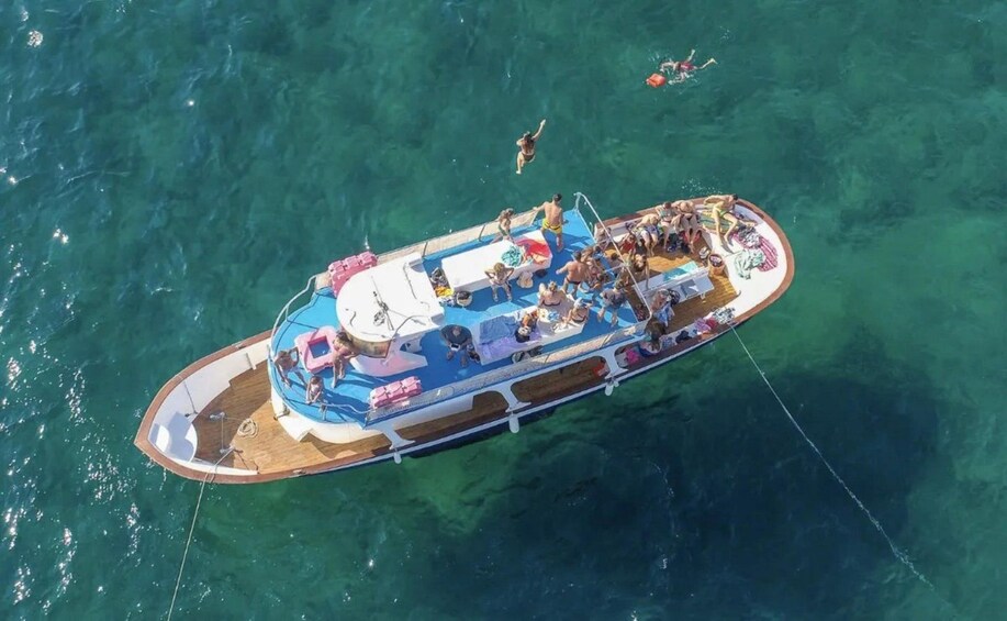 Un bote con gente tomando el sol y nadando en aguas cristalinas. 5