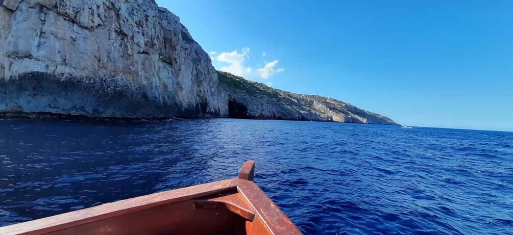 A boat on the sea with a rocky cliff in the background. 5