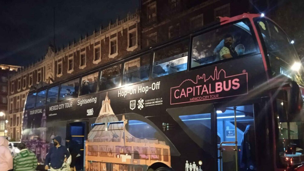 Un autobús de dos pisos con anuncios de 'Capital Bus' y 'Tour por la Ciudad de México'. 5