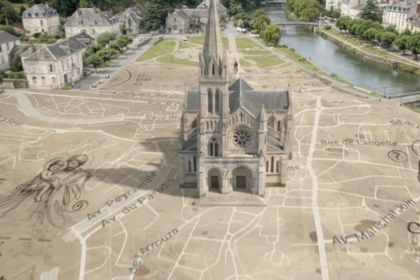 A model of a cathedral with a tall spire, surrounded by a detailed map of a city with streets and landmarks. 2