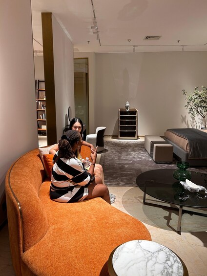 Ein modernes Wohnzimmer mit einem großen, orangefarbenen Sofa, einem Glastisch und einem beigefarbenen диван. 5