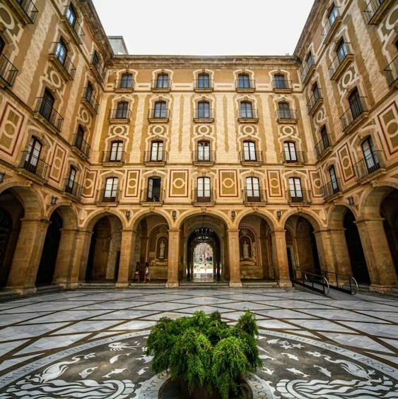 A courtyard with a central fountain, surrounded by classical architecture with arched doorways and columns. 2