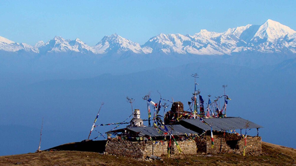 Een traditionele Tibetaanse gebedsbannerconstructie op een bergtop, met besneeuwde bergen op de achtergrond. 3