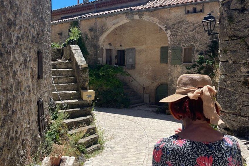 A stone staircase leading to an arched doorway, a cobblestone path, and a person wearing a hat. 5