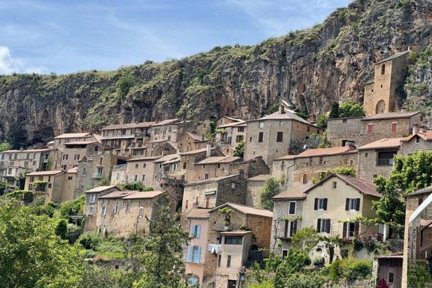 A hillside village with terraced houses and a prominent tower. 1