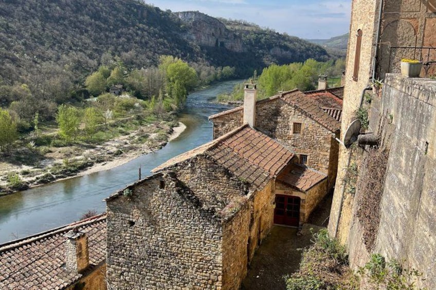A river flowing through a valley with stone buildings and a tower. 3