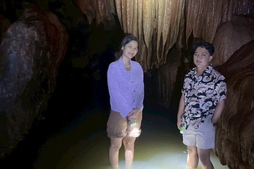 Two people standing in a cave with stalactites. 3