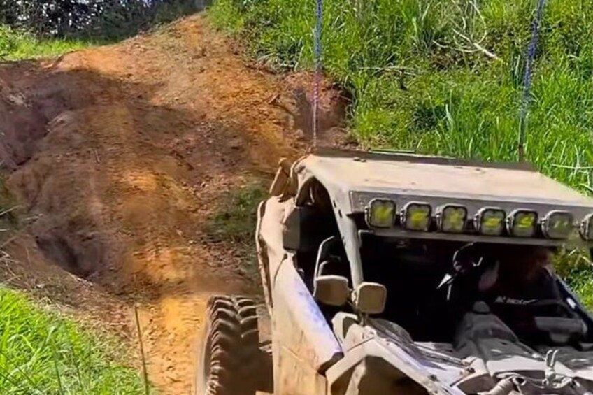 A vehicle navigating a steep, unpaved dirt path in a natural setting. 2