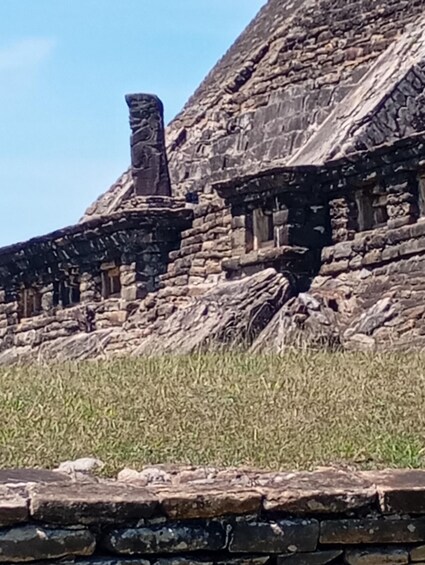 Ancient stone ruins with a large stone figure and a stepped structure. 1
