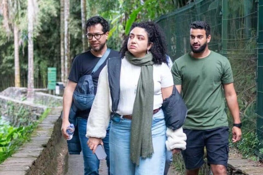 A group of people walking on a path surrounded by greenery. 1