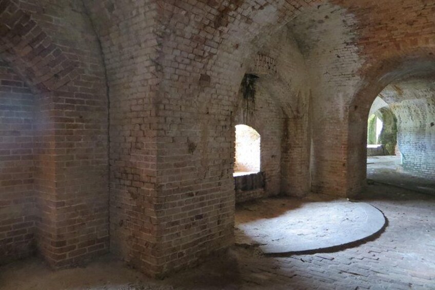 An ancient brick structure with arched passageways and a circular floor area. 3