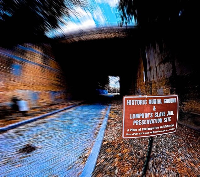 Un cementerio histórico y un cartel de preservación del sitio de una cárcel de esclavos en un túnel. 2