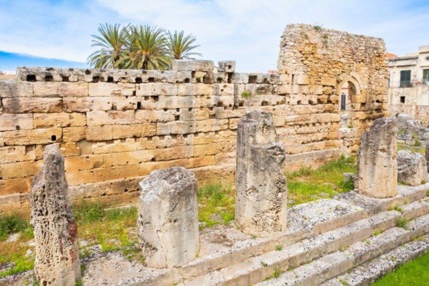 Ancient ruins with stone columns and a brick wall. 3