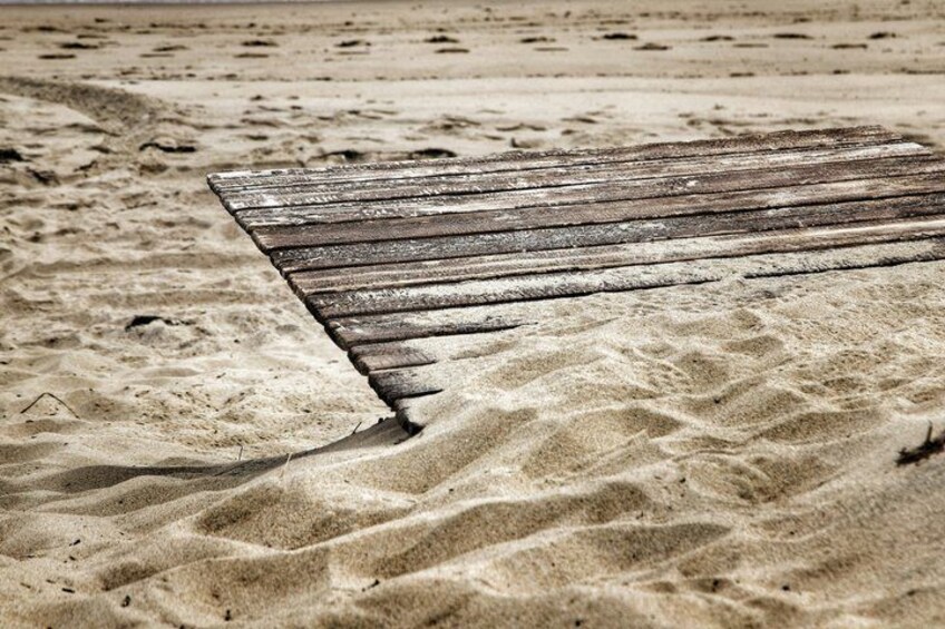 A wooden boardwalk on a sandy beach. 3