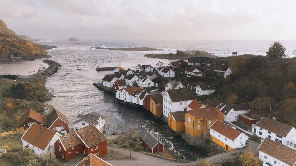 Un village côtier avec des maisons construites le long de la plage, une côte rocheuse et une île visible au loin. 5