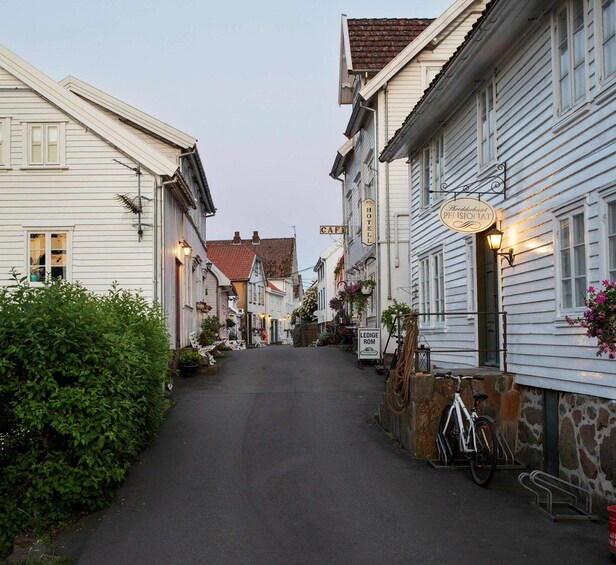 Une rue étroite bordée d’immeubles blancs, d’un café et d’un hôtel. 2