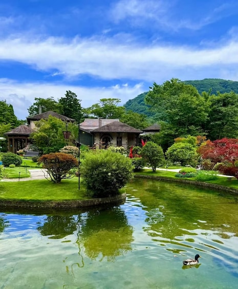 A tranquil garden with a pond, lush greenery, and traditional buildings. 2