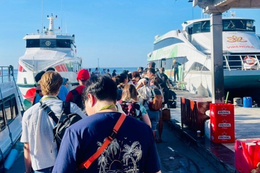 A group of people boarding a boat. 2