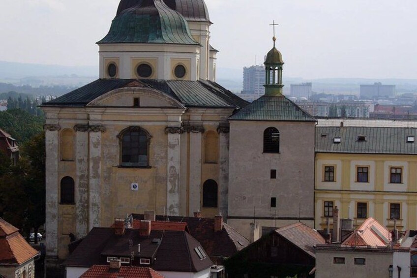 A historic church with a green dome and bell tower, surrounded by urban buildings. 3