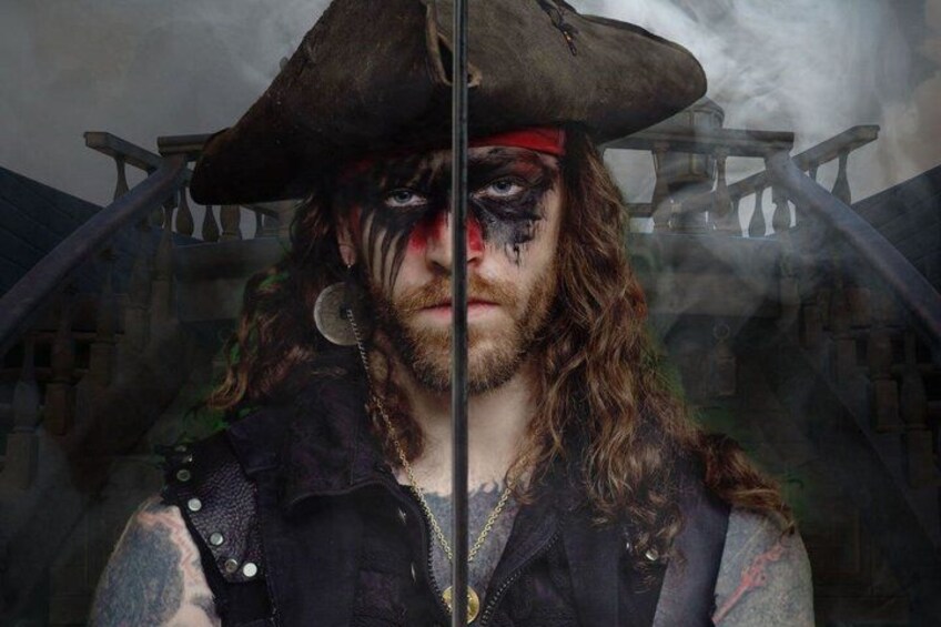 A person with a pirate hat, tattoos, and a necklace. 1