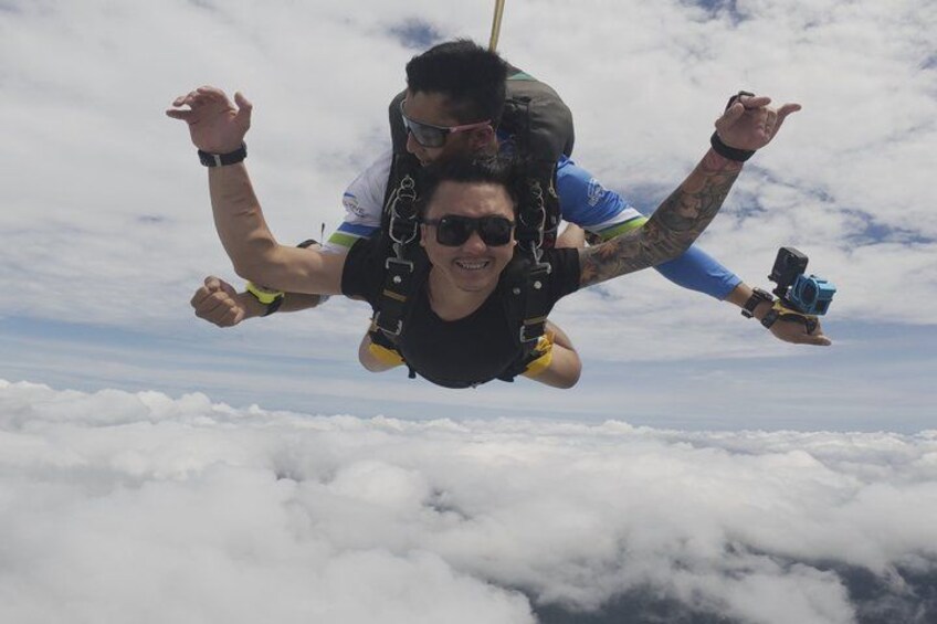 Two people skydiving above clouds. 1