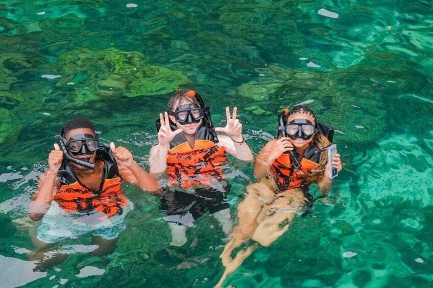 Three people snorkeling in clear water. 3
