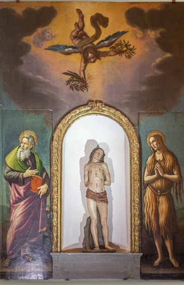 Il s’agit d’une peinture religieuse dont le sujet central est une crucifixion, encadrée de deux figures : l’une tient un livre et l’autre est en prière. 5