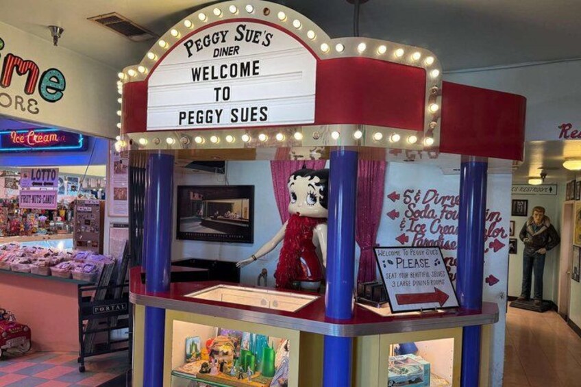 A diner named Peggy Sue's with a sign welcoming visitors. 2