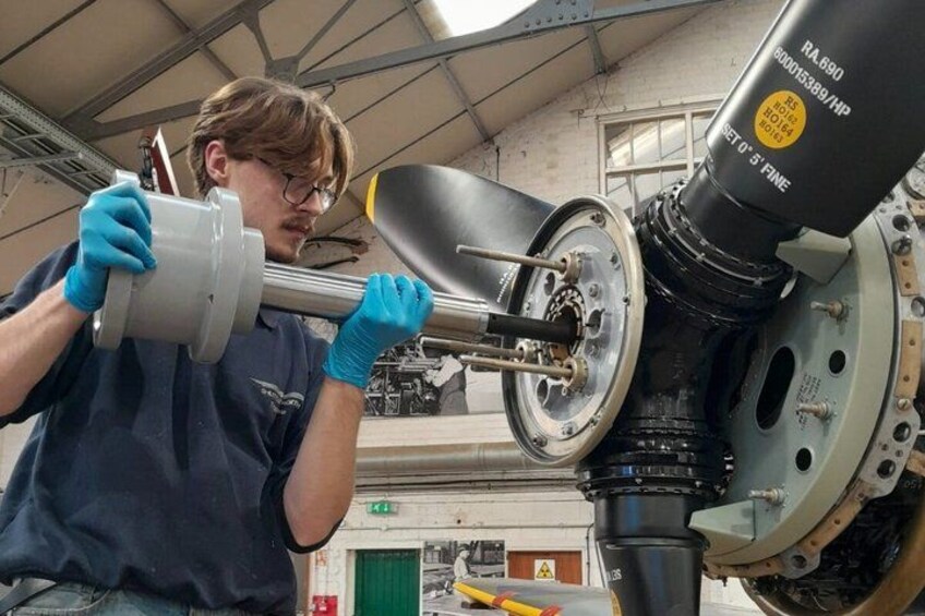 A person working on a vehicle's wheel hub assembly in a workshop. 4