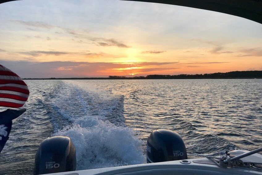 A boat's wake on water with a sunset in the background. 3