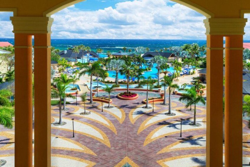 A resort with a pool, palm trees, and a view of the ocean. 5