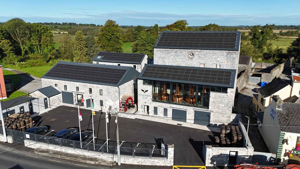A distillery with a stone building and solar panels. 3