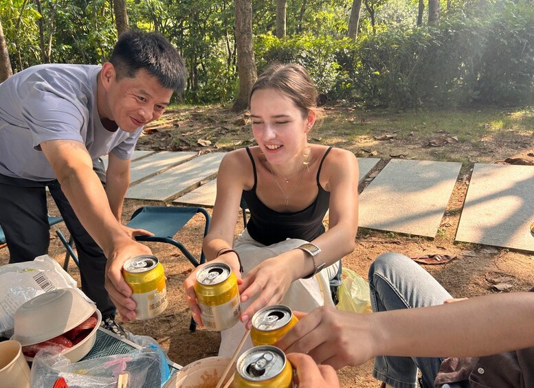 Twee personen buiten aan het zitten, één met een blikje drank. 1