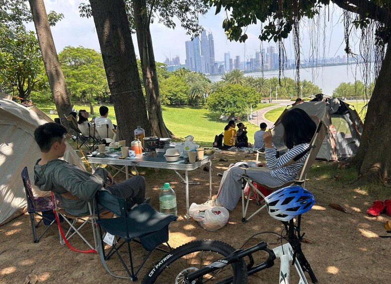 Een kampeerterrein met tenten, een tafel met eten en drinken, en een fiets. 5