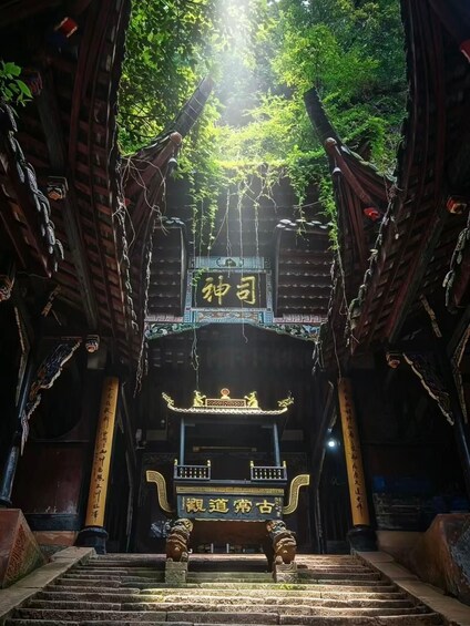 A traditional Chinese gate with intricate designs and characters, leading to a staircase. 3