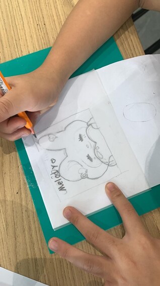 Une personne qui dessine sur une feuille de papier avec un crayon. 2
