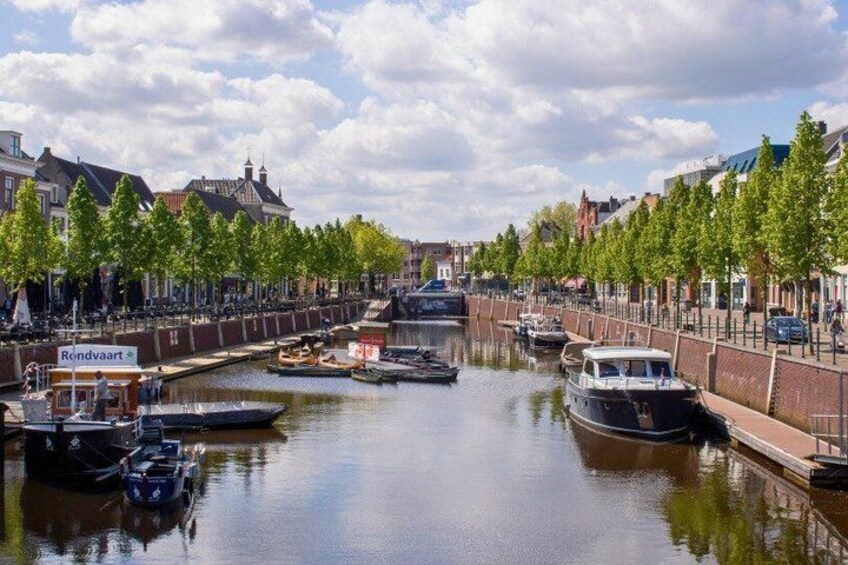 A canal with boats, trees lining the banks, and buildings in the background. 3
