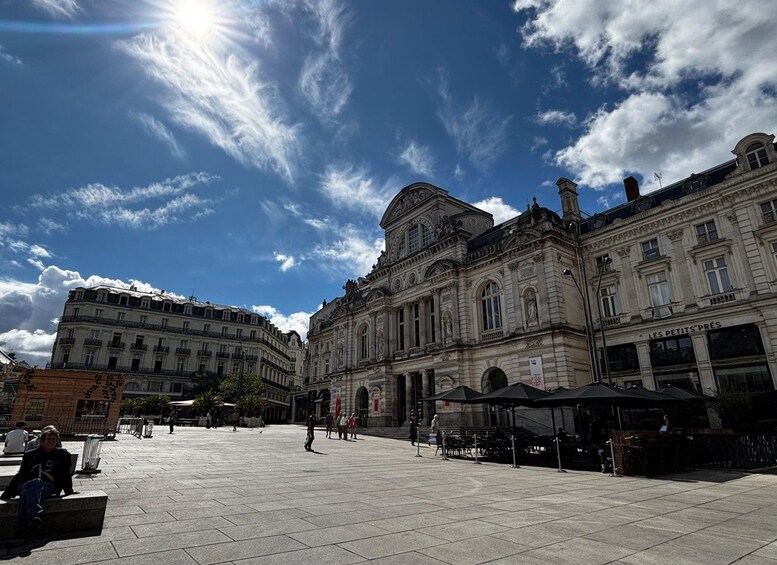 Una gran plaza abierta con edificios históricos, cielo despejado y algunas personas caminando. 2