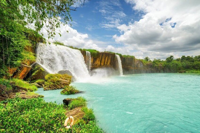 Una cascada vertiéndose en una piscina turquesa rodeada de exuberante vegetación. 1
