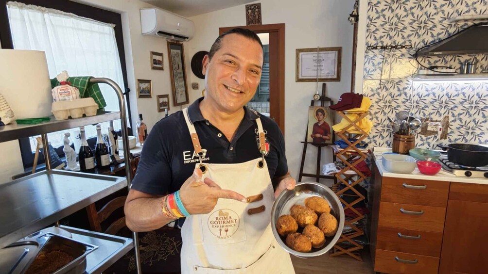 Eine Küche mit einer Person, die eine Kochschürze trägt und eine Schüssel mit Essen hält. 1