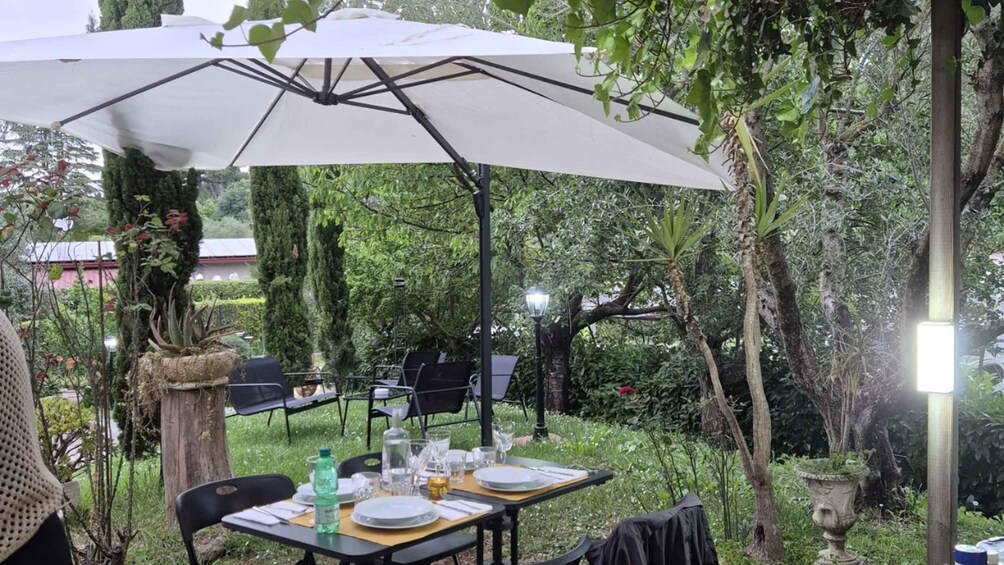 Ein Essbereich im Freien mit Tischen, Stühlen und Sonnenschirmen. 4
