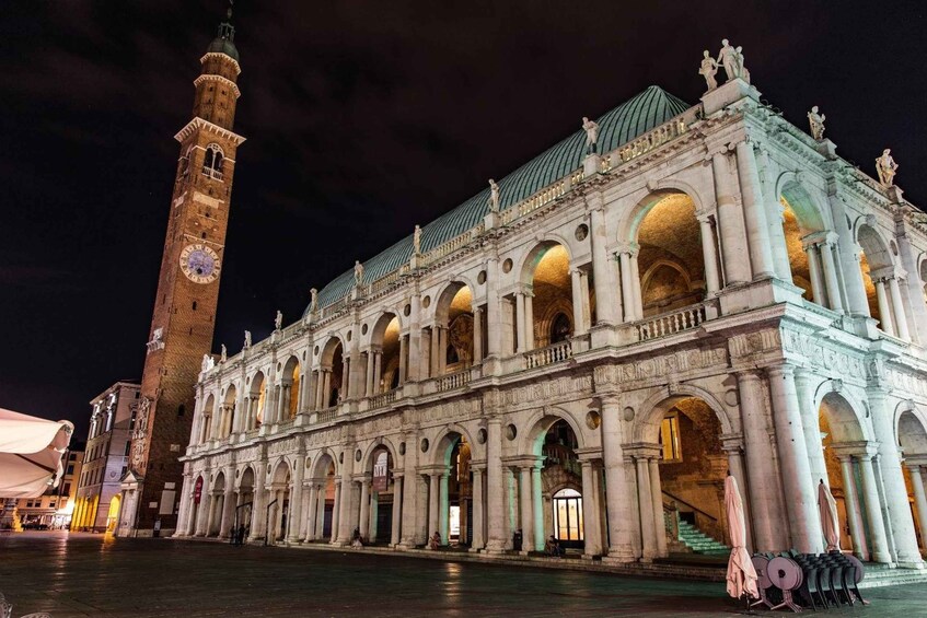 A historic building with a clock tower and arches. 5
