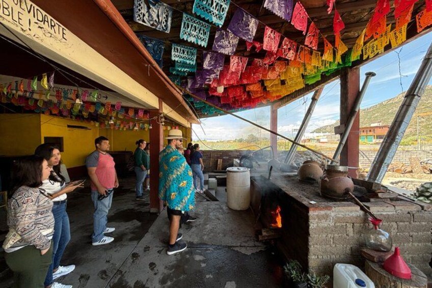 A traditional kitchen with a wood-fired stove, colorful paper decorations, and a brick oven. 5