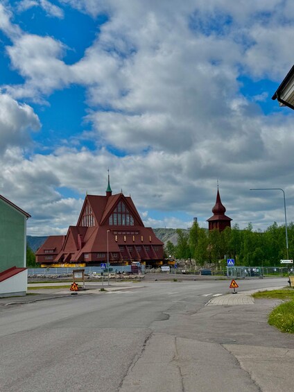 A large red building with a pointed roof and a smaller tower in the background. 3